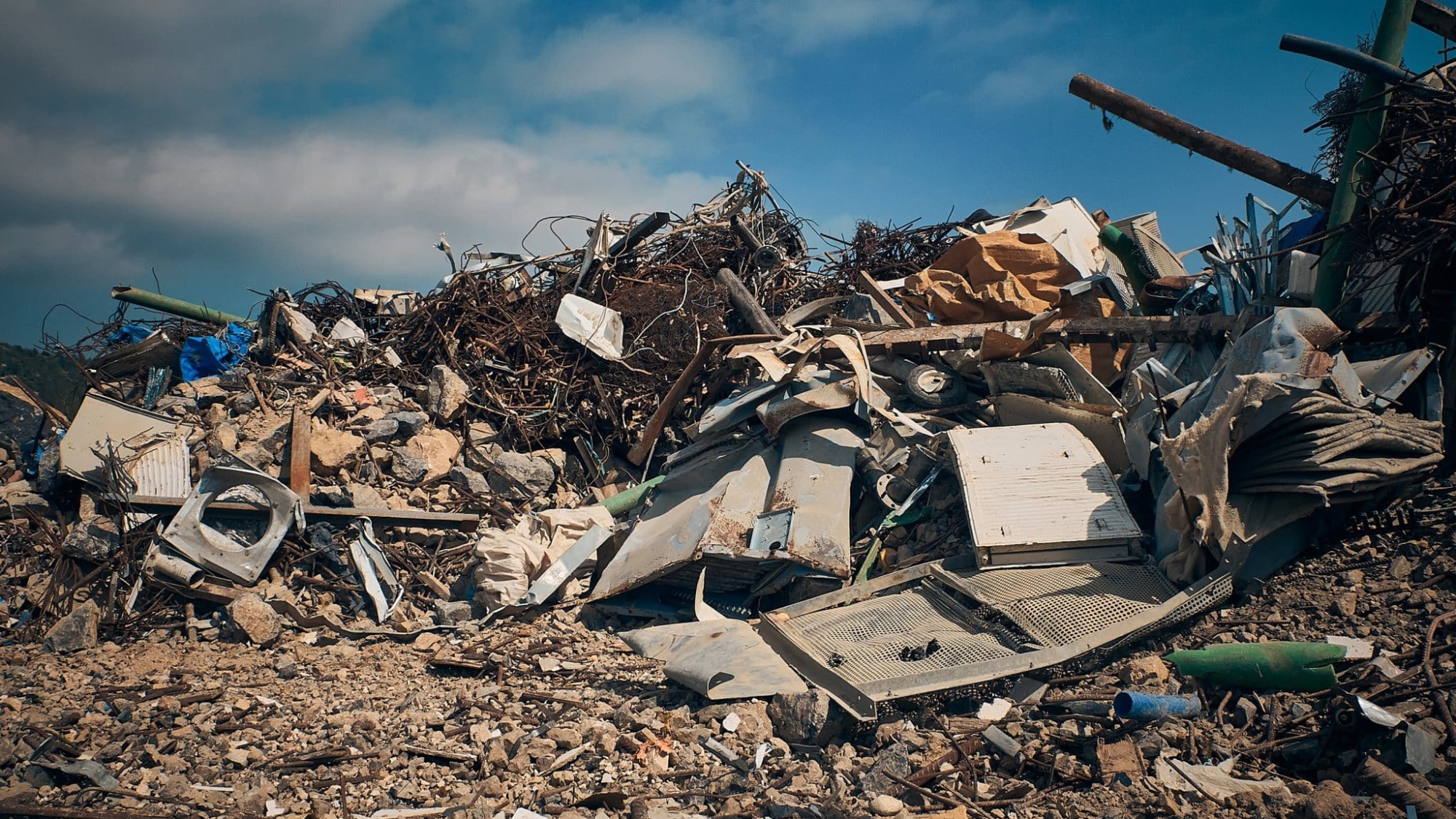 Metal reinforcement rods, lumber and other different kinds of construction debris piled. Construction garbage dump.