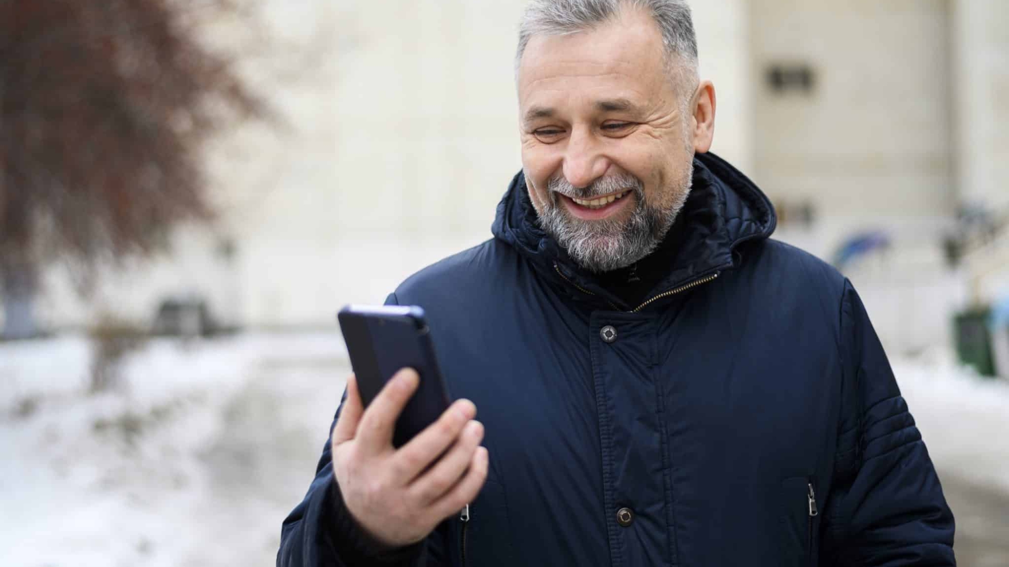 mature-man-looking-his-phone-outdoors