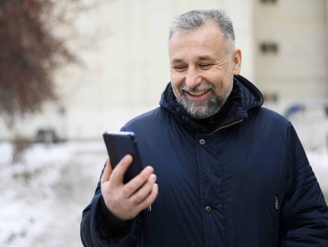 mature-man-looking-his-phone-outdoors